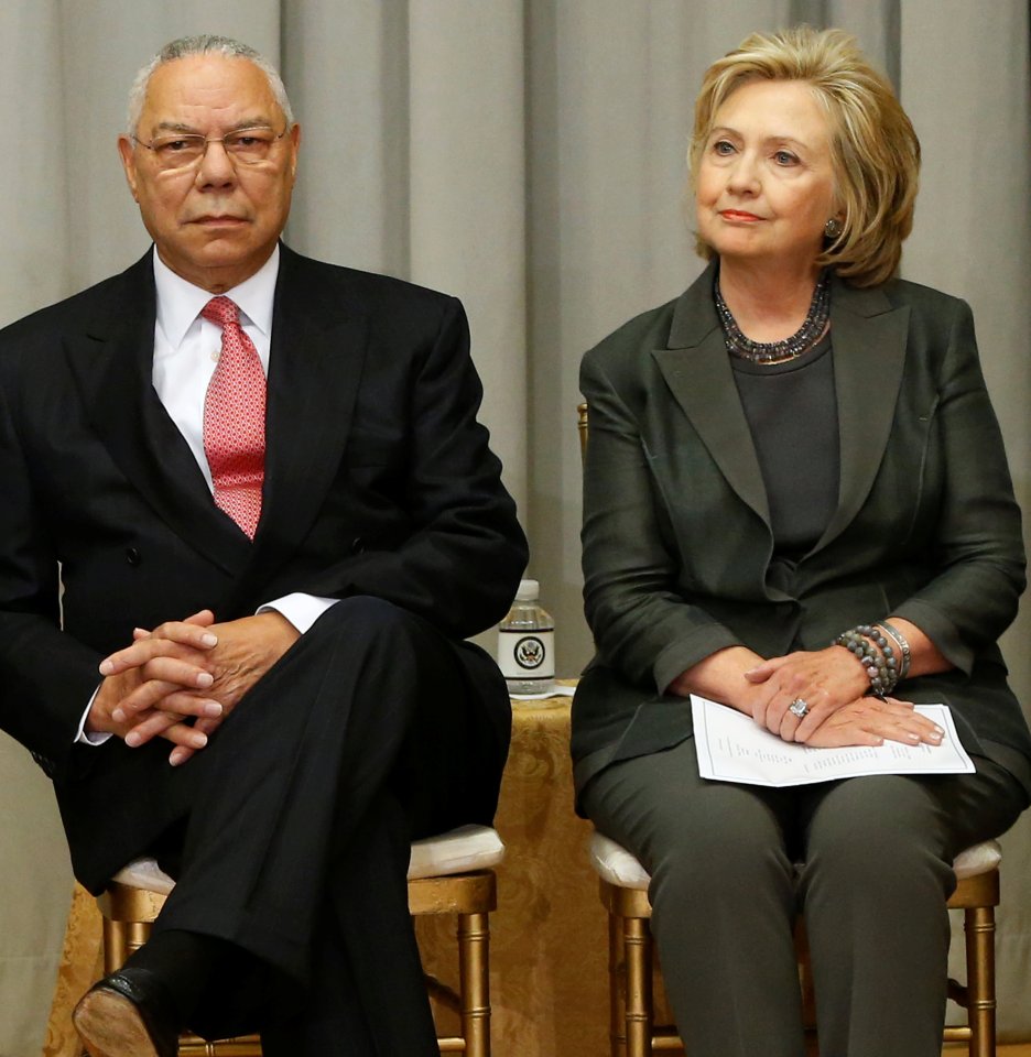 Powell and Clinton listen to remarks at a groundbreaking ceremony for the U.S. Diplomacy Center at the State Department in Washington