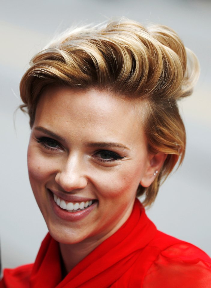 The actress has her hair styled in a blown-back do