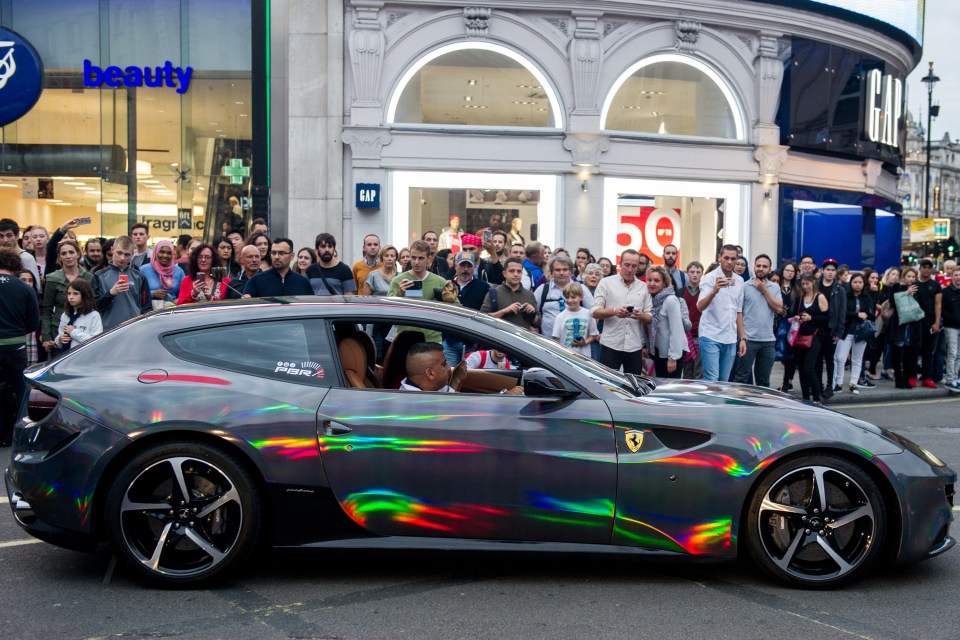 Dozens or onlookers jostled to catch a glimpse of the cars as they moved through West London