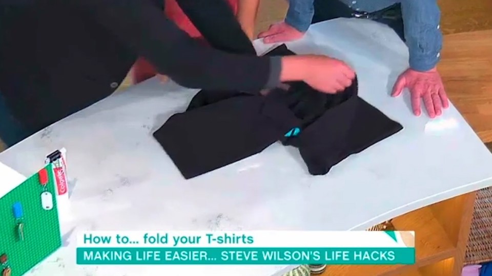 Still pinching at point A, he then folded the T-shirt over from point B to point C