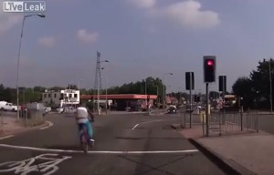 Moment idiot cyclist flies across busy junction dodging traffic as he goes - and he wasn't wearing helmet