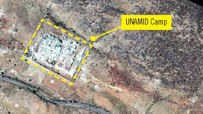 Many small white tarps from displaced civilians, are erected outside of the UNAMID Sortoni Camp walls