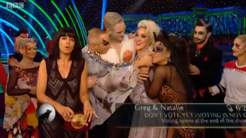 Other contestants gather around to hug an upset Natalie