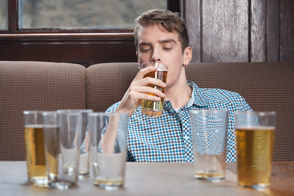 Young man drinking beer in bar
