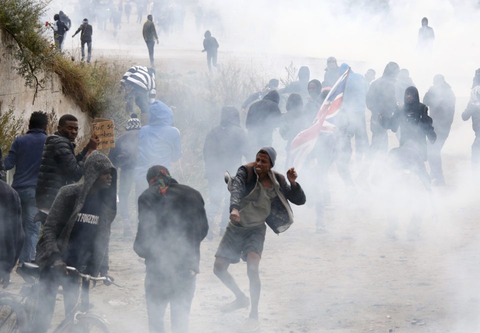 Tear gas fills the air as French riot police face off with demonstrators near the area called the "jungle" 