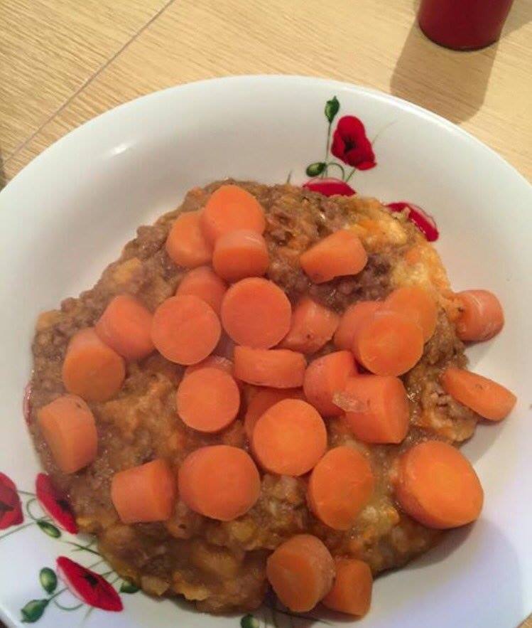 Carrots are dumped on top of a pile of brown mush 
