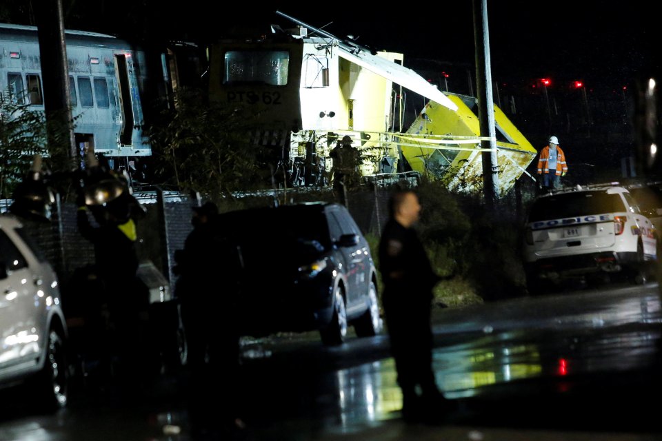 Emergency responders work near a train that sits derailed near the community of New Hyde Park on Long Island in New York