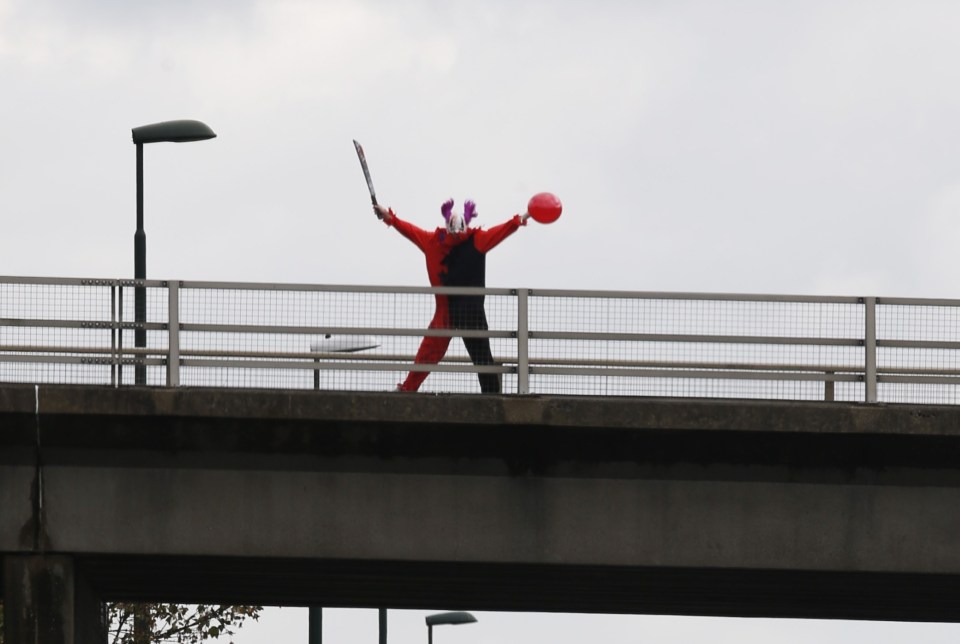 FAMEFLYNET - Exclusive: The Killer Clown Craze Shows No Sign Of Slowing Down As An Individual Dressed As A Clown Brandishing A Sword Is Seen On A Bridge Taunting Traffic Below On The M20