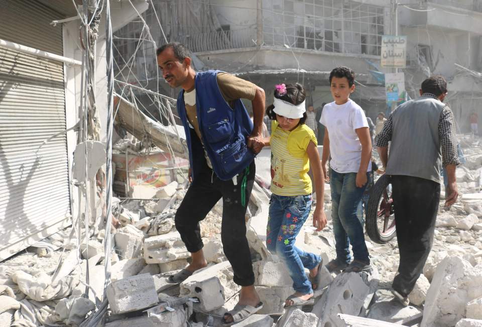 Injured residents walk over rubble following Russia's bombardment of Fardous