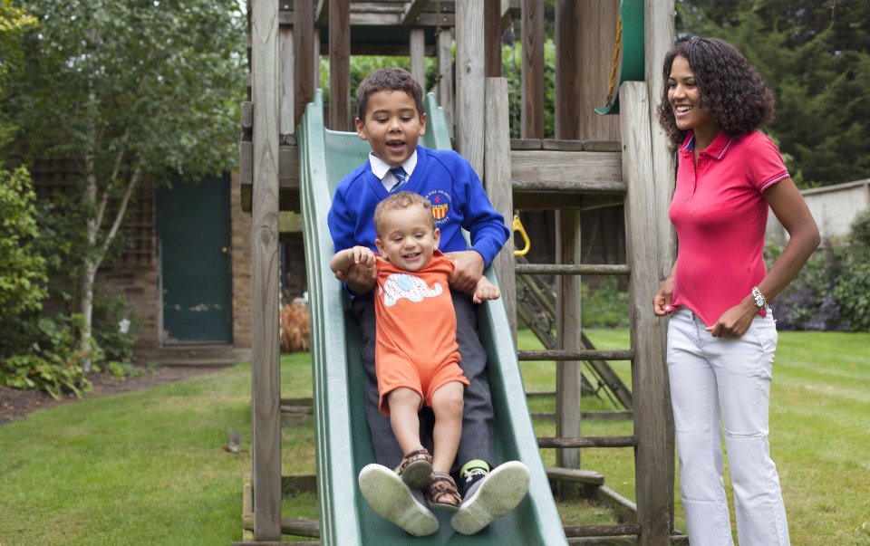 family playing on a slide in the garden