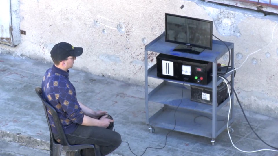 A man purportedly monitors the gun's targets using a TV camera
