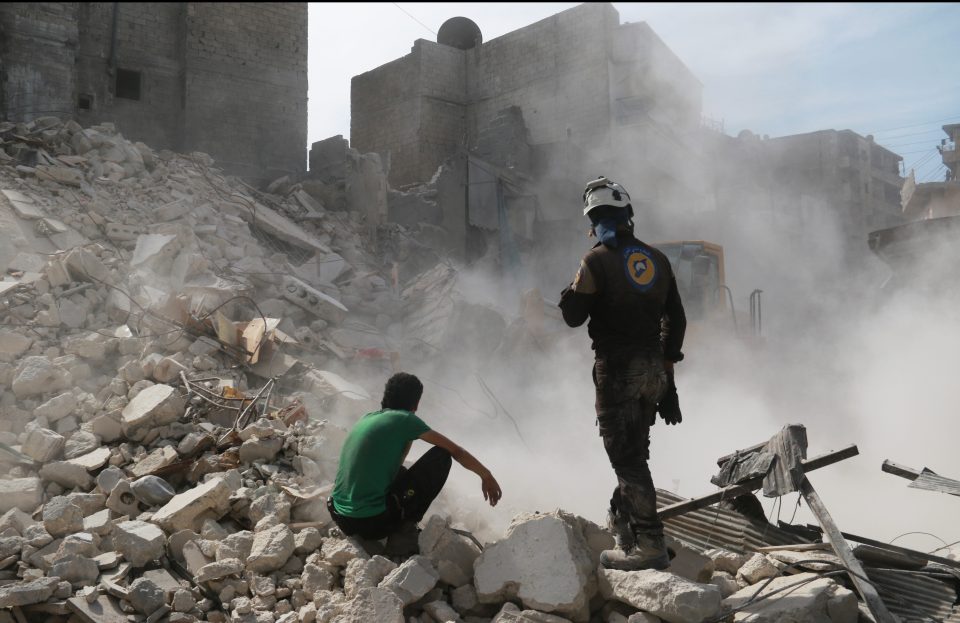 Syrian residents inspect the debris caused by the bombing