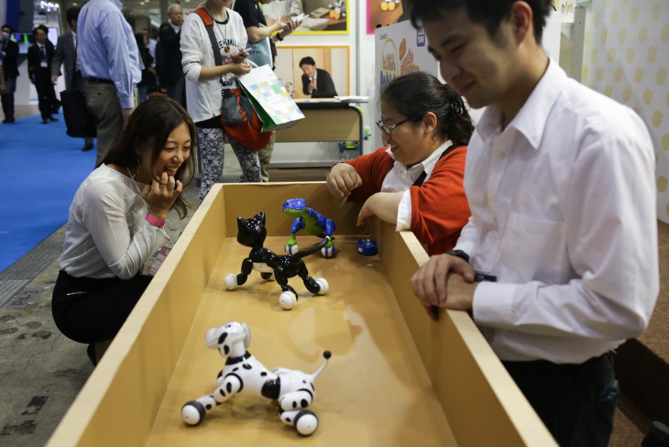 A guest plays with the Pet Robot 'Hello! Woonyan' developed by Takara Tomy