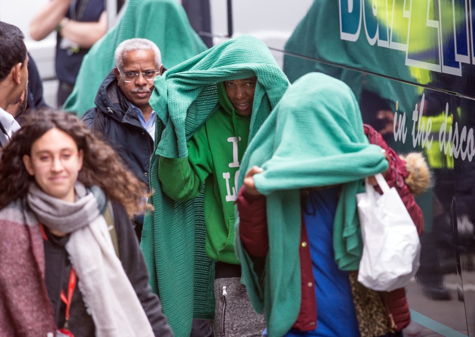 Some of the migrant children covered their faces as they arrived at in Croydon