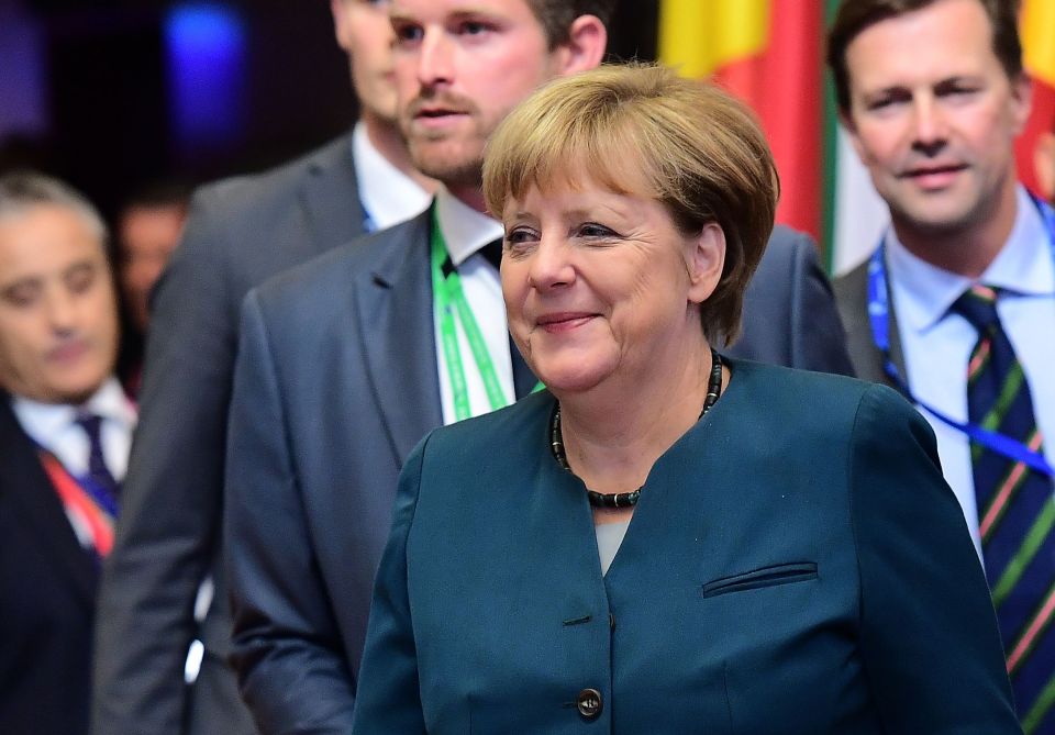 German Chancellor Angela Merkel looks on as she leaves the European Union leaders summit