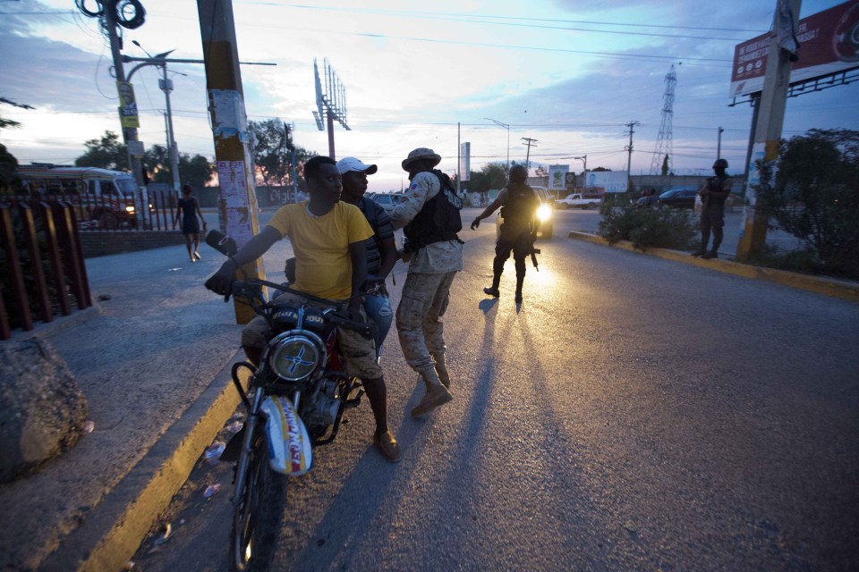Prison guards check motorists as they hunt for the escapees