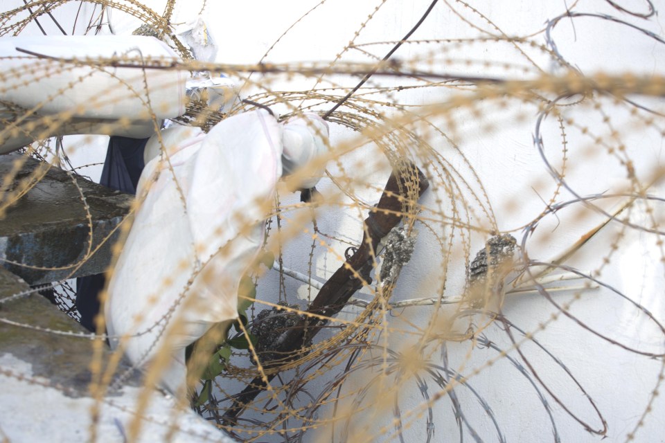A prison guard's gun lays among barbed wire on the roof of the Civil Prison after the jail break