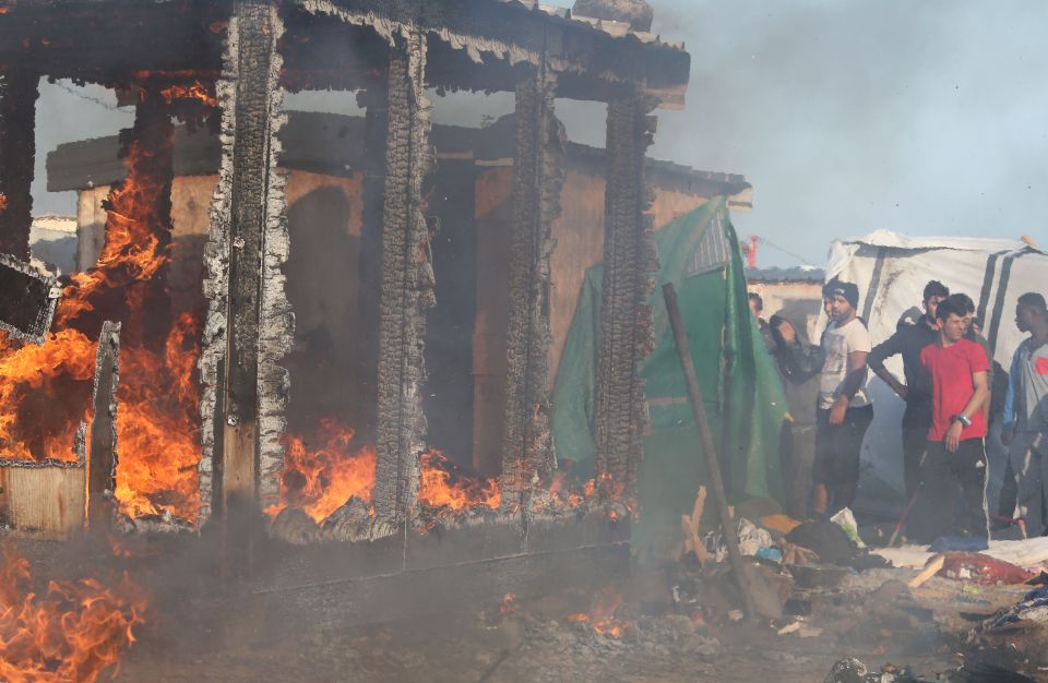 Scorched earth ... Migrants light fire to buildings in the Jungle camp as violence errupts