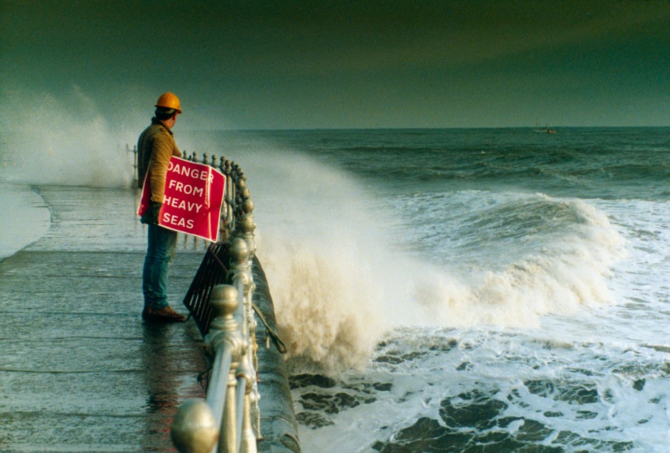 Workman on stormy sea front