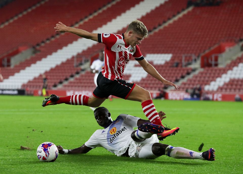 Sunderland's Papy Djilobodji (right) slides in to challenge Southampton's Lloyd Isgrove during the EFL Cup clash