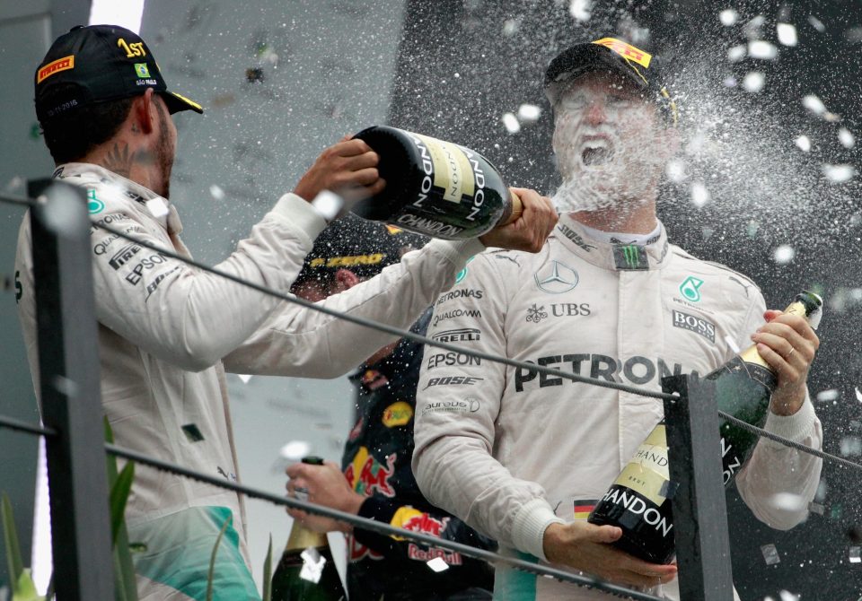 Brazilian GP winner Lewis Hamilton celebrates with runner-up and title-race leader Nico Rosberg 