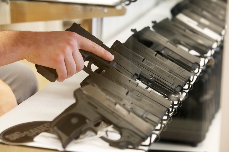 A handgun is pulled form the case at the "Ready Gunner" gun store