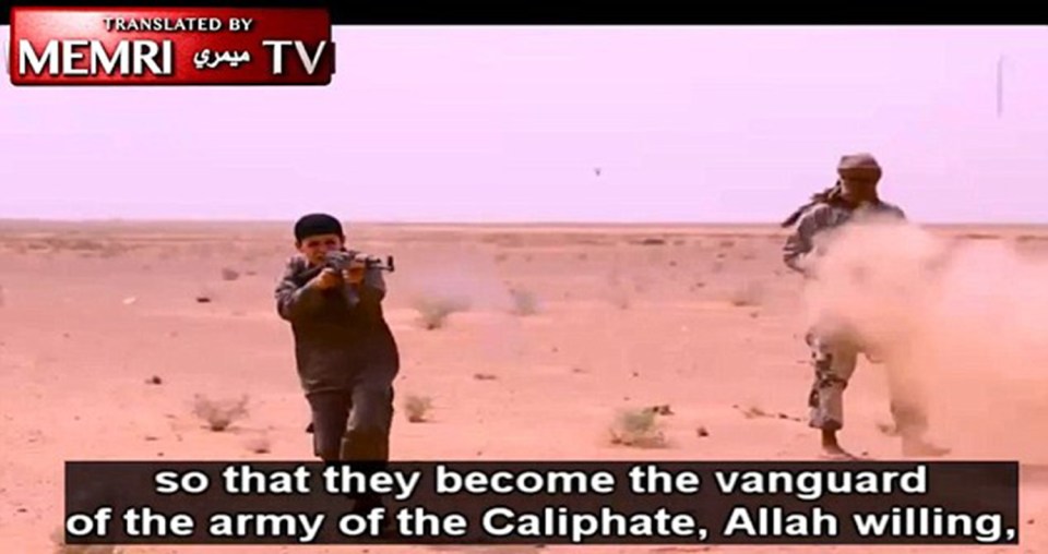Twisted ...another video grab shows a little boy learning how to use a gun in combat