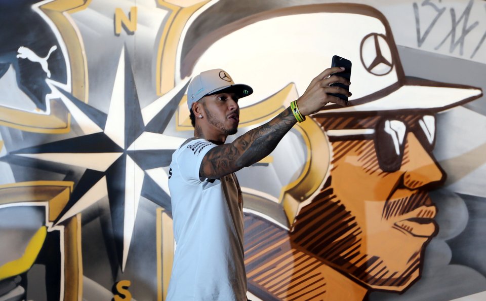 Hamilton takes a selfie ahead of the Brazil GP next to a graffiti artwork of himself