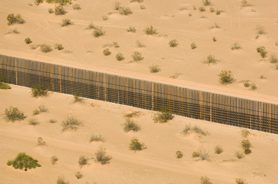 US Mexico Border fence, AERIAL, Imperial Dunes near Calexico, California