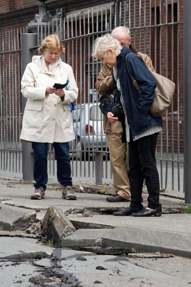 Members of the public inspect the damage to the road on the Wellington water front 