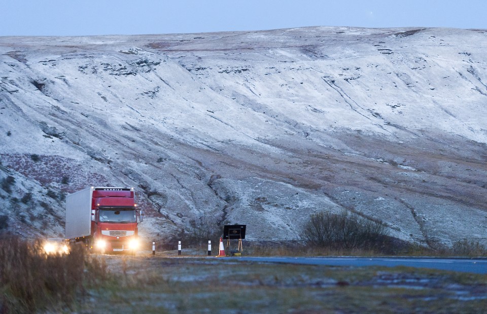 A lorry drives through a valley in the Brecon Beacons, Wales as it became another part of the country to receive a dusting
