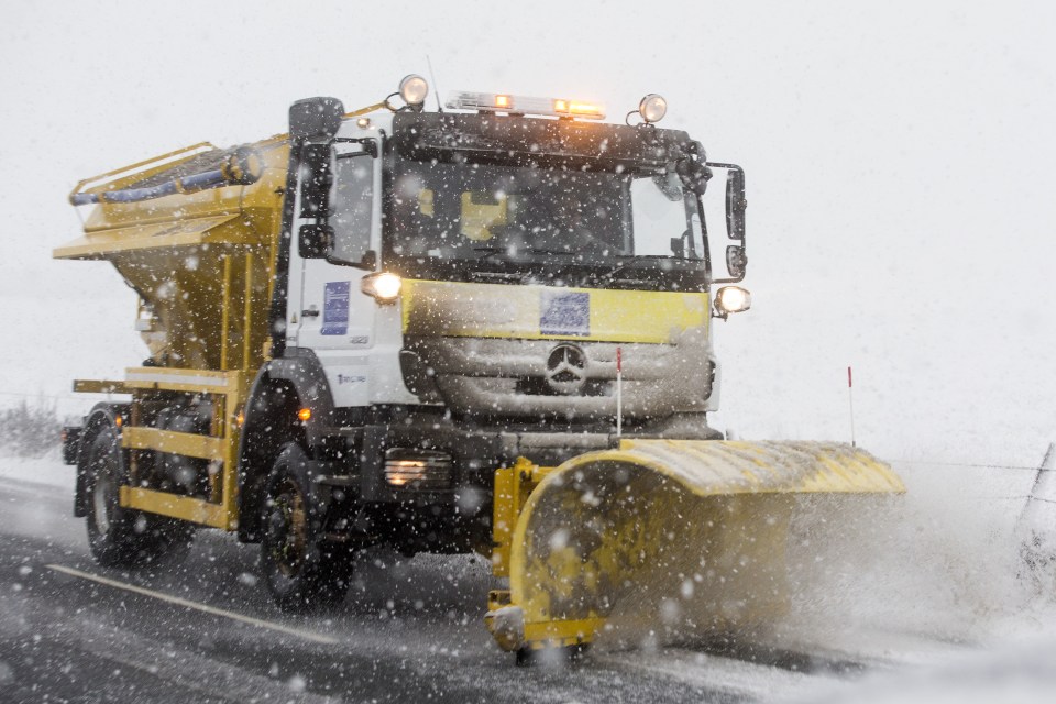 A gritting truck fitted with a snowplough steams down a road in Ingleton, Yorks. clearing the way for motorists 