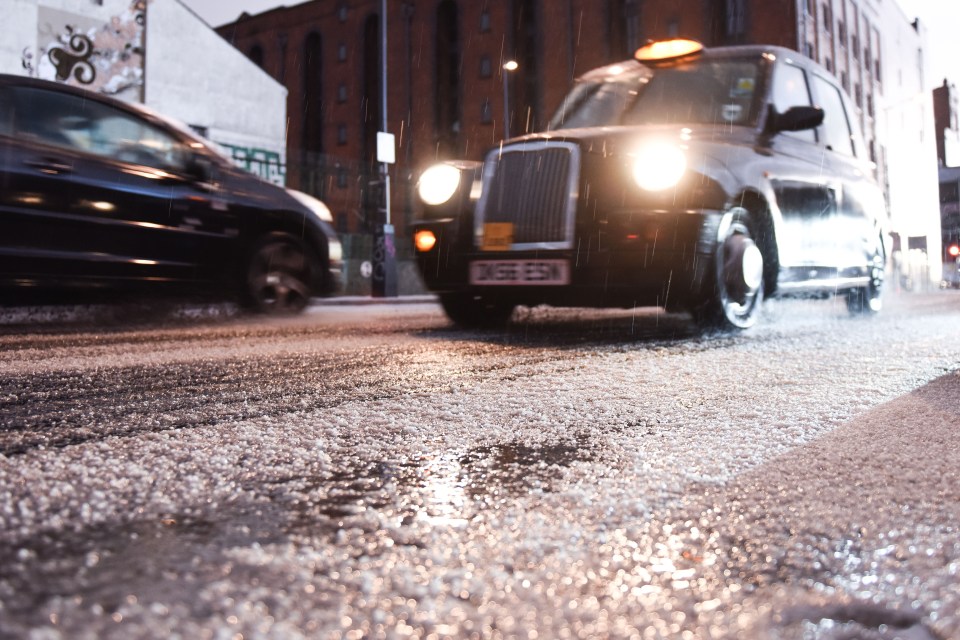 A Taxi in Liverpool makes its way though the city centre following a heavy hail storm this morning 