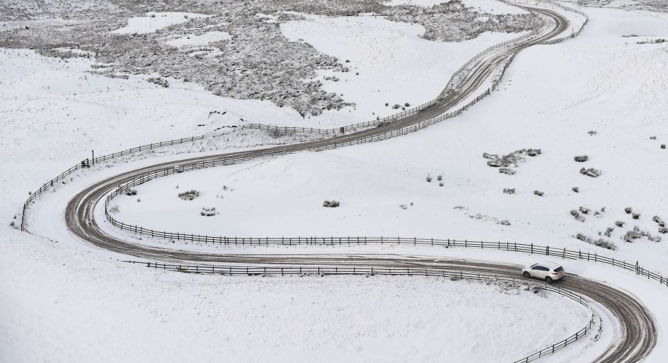 A car makes its way along icy road near Mam Tor in Derbyshire after winter weather brought snow to high ground across the Peak District