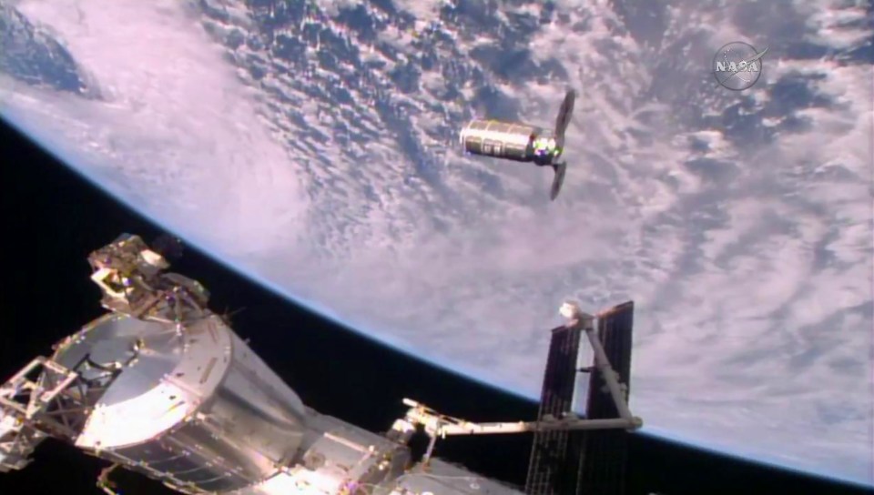 The Cygnus cargo ship slowly approaching the International Space Station (ISS) for docking