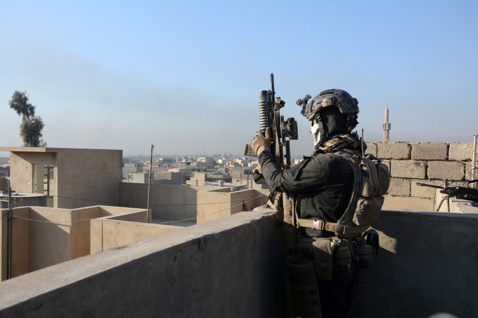 Members of the Iraqi Special Operations Forces (ISOF) take position during a battle with Islamic State militants in Mosul