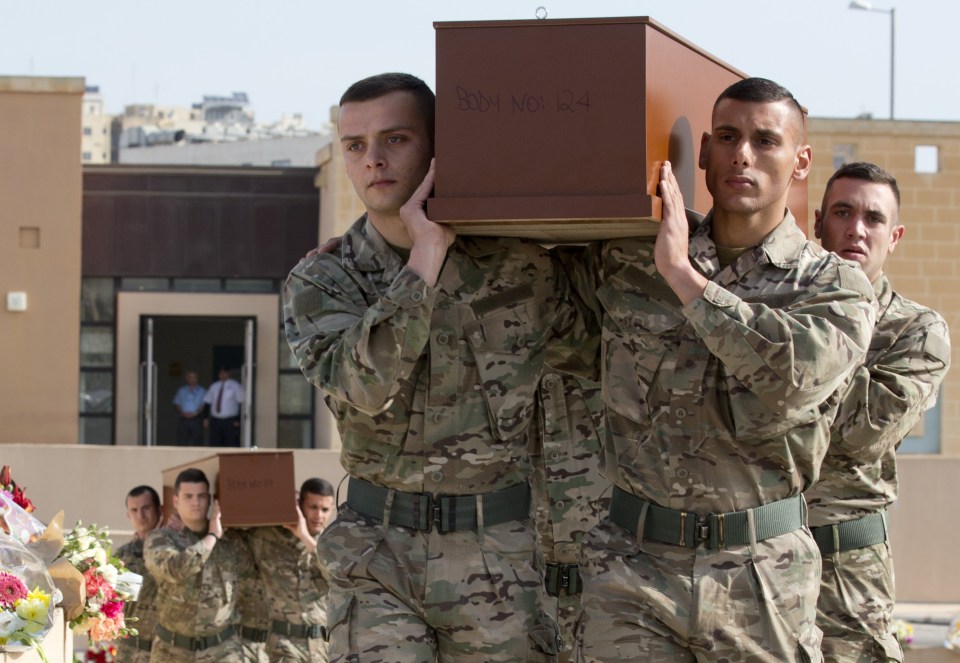 Soldiers carry the coffins during a funeral service for 24 migrants drowned while trying to reach the Southern coasts of Italy, in Msida, in the outskirts of Valletta, Malta, Thursday, April 23