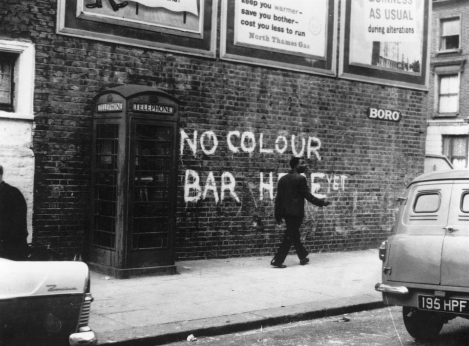 Around 1959: A black man walking down a Notting Hill Street, where race riots had recently taken place