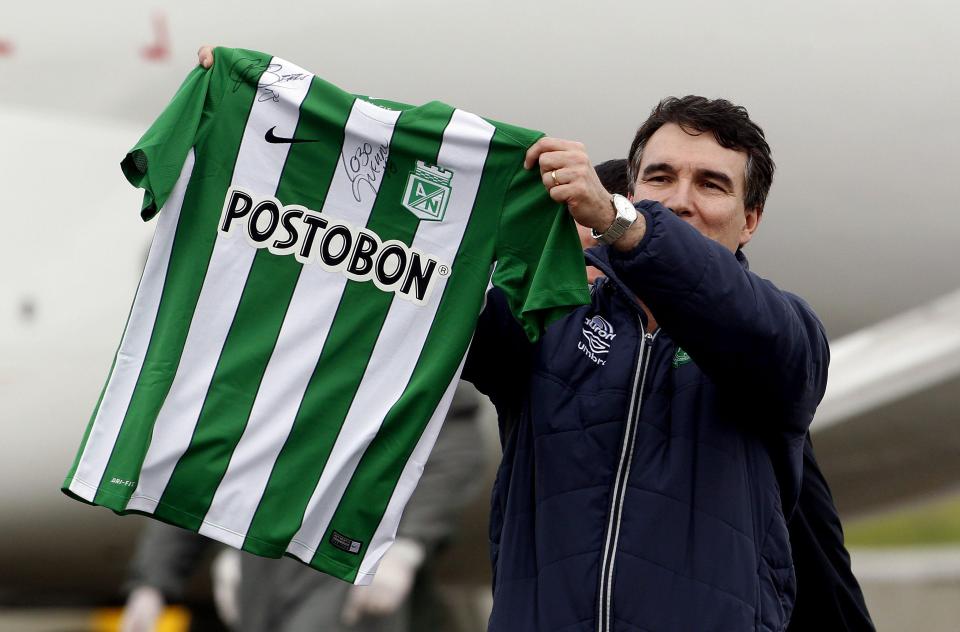  Chapecoense physician Carlos Mendonza waves the teams shirt before boarding a plane