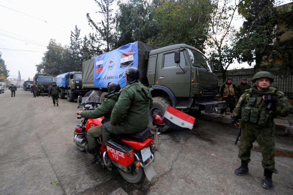 Russian soldiers stand near their vehicles in Aleppo, Syria