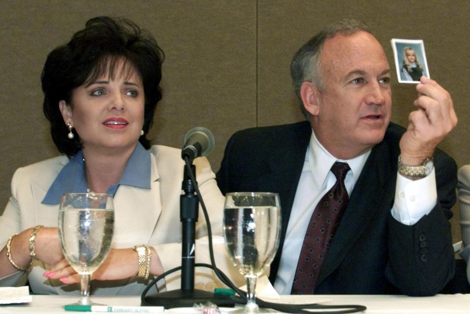 Patsy Ramsey and her husband, John Ramsey, produce a picture of Jon-Benet Ramsey during a news conference in Atlanta, Georgia, on May 24, 2000
