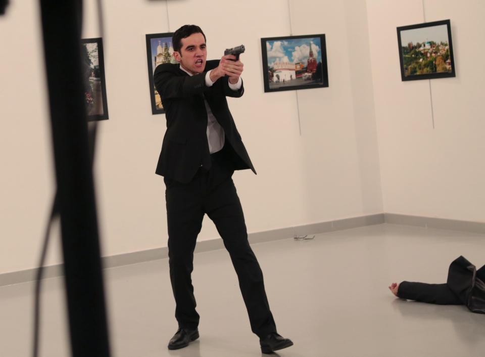 The attacker brandishes his pistol after shooting down the ambassador