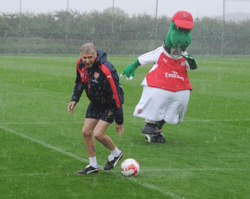 Arsene Wenger fools around with Gunnersaurus Rex during Christmas training