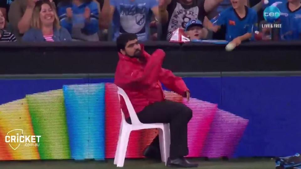 Security man casually throws the ball back onto the field of play following casual grab