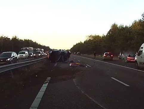  Drivers rush to the aid of the people inside the stricken vehicle