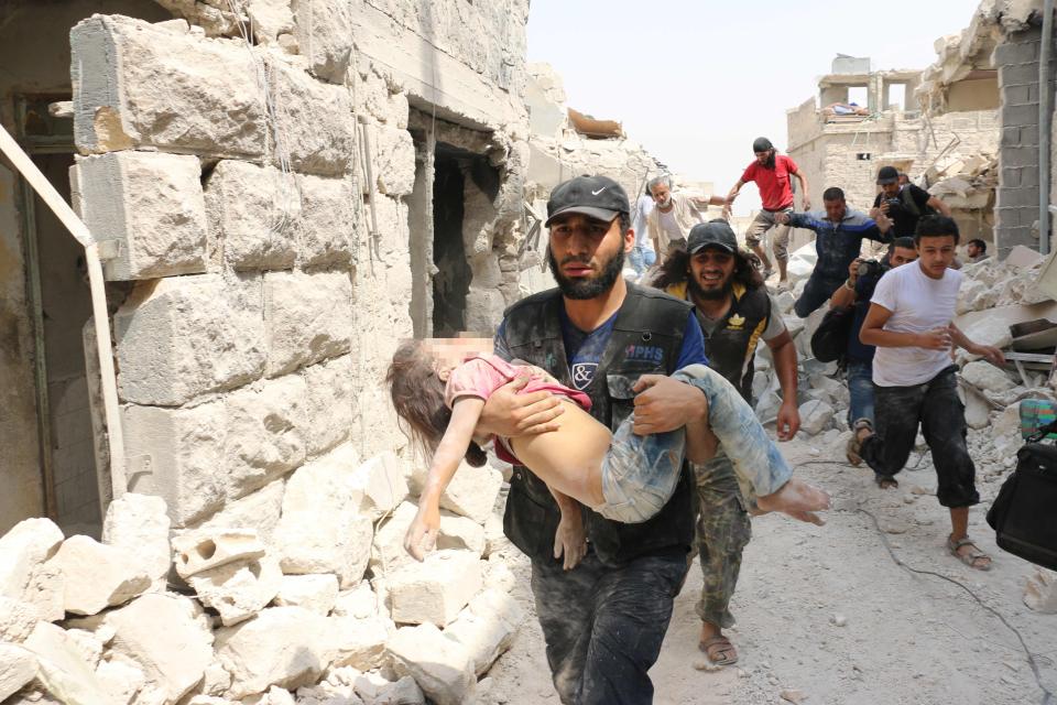 A injured child is carried out of a bombed home after Russian airstrikes on Aleppo 