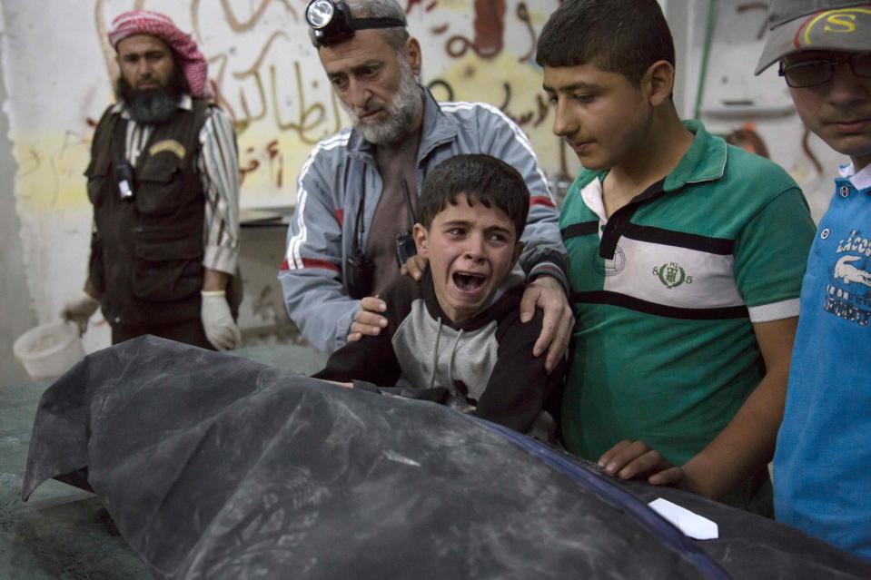 A boy from Aleppo howls after family members are butchered in air raid