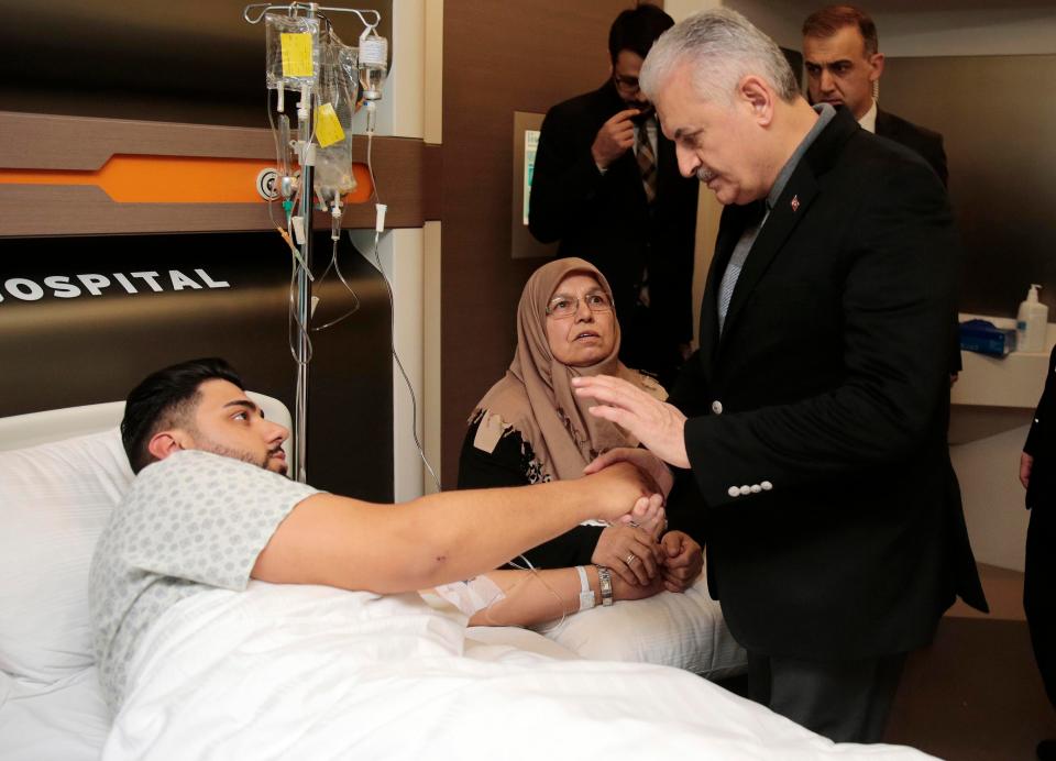 Turkey's Prime Minister Binali Yildirim speaks with one of the survivors
