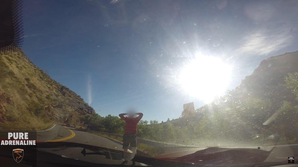 The driver can barely believe what has happened as he jumps from the vehicle with his hands behind his head