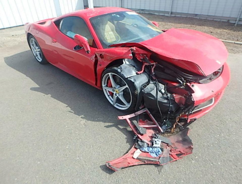 The red Ferrari lies wrecked with extensive damage to its front